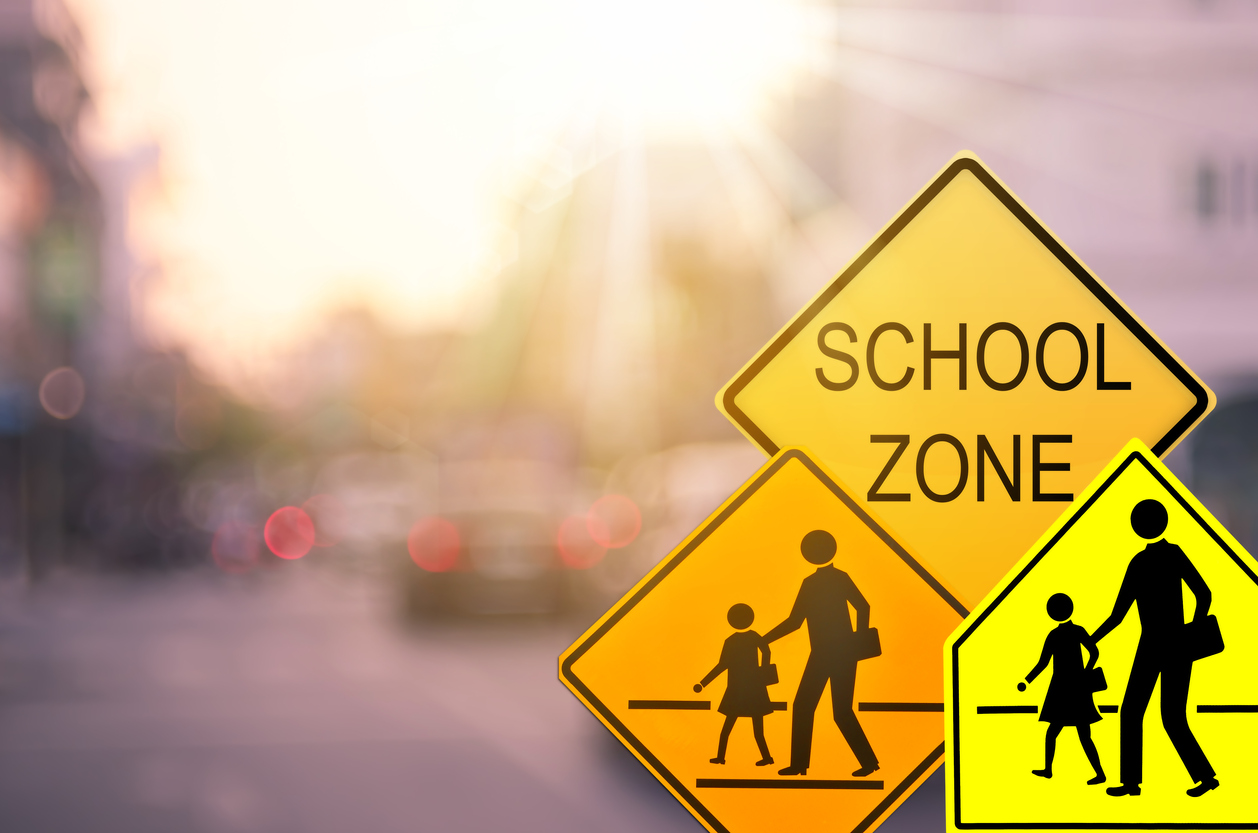 Three different yellow crosswalk signs show a school crossing zone.