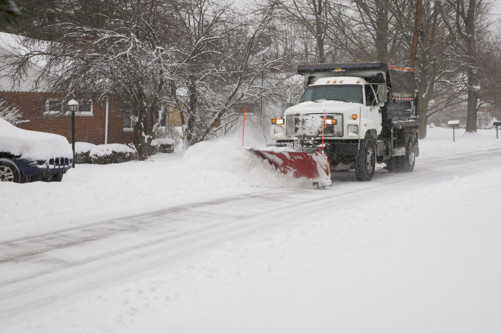 A snow plow clears a local road after a winter storm.