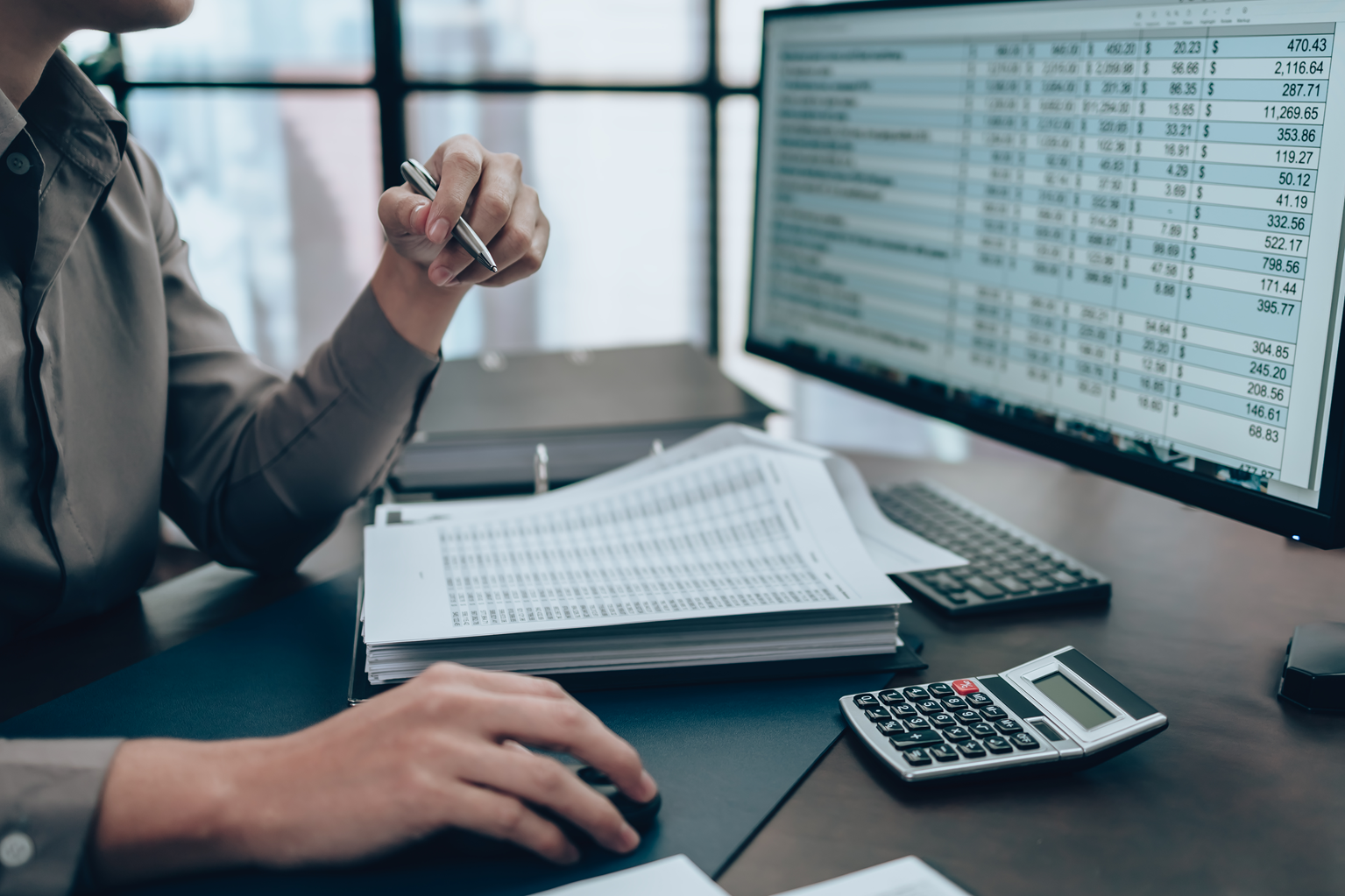 An accountant analyzes a fixed asset report on a computer.
